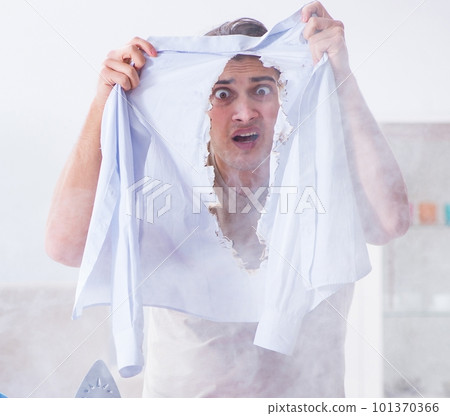 Inattentive husband burning clothing while ironing 101370366