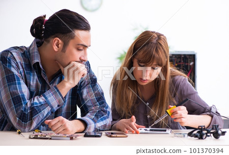 Two technicians working at computer warranty center 101370394