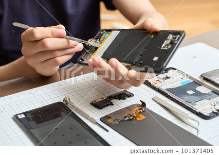 Hand disassembling smartphone 101371405