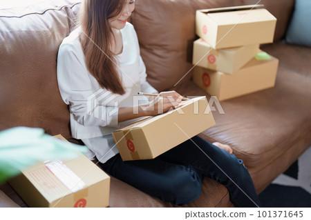 Starting small business entrepreneur of independent Asian female online seller packing products to send to customers and SME delivery concept. Starting small business entrepreneur of independent Asian female online seller packing products to send to customers and SME delivery concept. 101371645