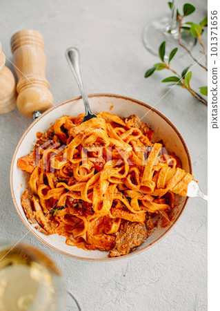 Pasta bavette with fried shrimps, bechamel sauce. Woman hands in frame, girl eats pasta, holds fork in hands, top view, italian cuisine. Pasta bavette with fried shrimps, bechamel sauce. Woman hands in frame, girl eats pasta, holds fork in hands, top view, italian cuisine. 101371656