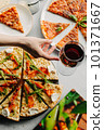 Traditional Italian pizza, vegetables, ingredients on a light background.Top view. a piece of pizza in the hand.Festive table. company of friends 101371667