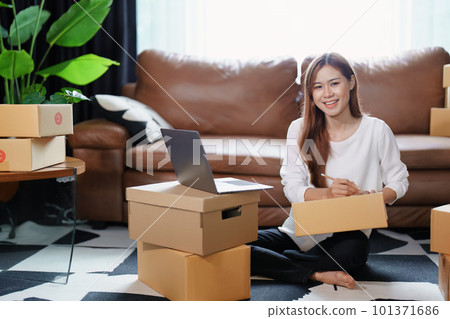 Starting small business entrepreneur of independent Asian female online seller packing products to send to customers and SME delivery concept. Starting small business entrepreneur of independent Asian female online seller packing products to send to customers and SME delivery concept. 101371686