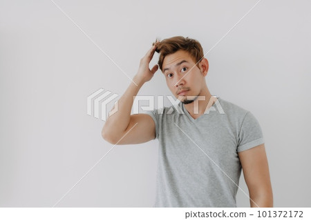 Man in grey t-shirt looking at his dyed hair doubtfully isolated on white. Man in grey t-shirt looking at his dyed hair doubtfully isolated on white. 101372172