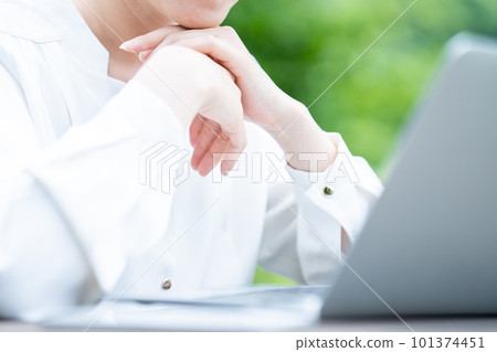 A woman using a laptop outdoors [parts cut] 101374451