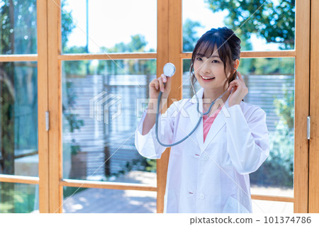 Young female doctor using a stethoscope Young female doctor using a stethoscope 101374786