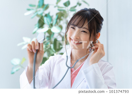 Young female doctor using a stethoscope Young female doctor using a stethoscope 101374793