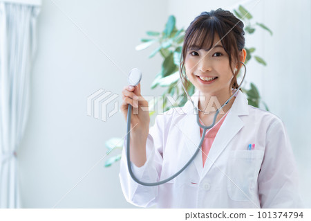 Young female doctor using a stethoscope 101374794