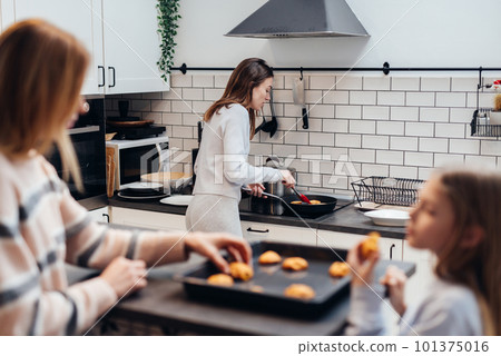 Young woman cooking pancakes in a frying pan Young woman cooking pancakes in a frying pan 101375016