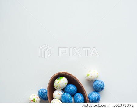 Colorful and chocolate easter eggs with sweet dragee on white background 101375372