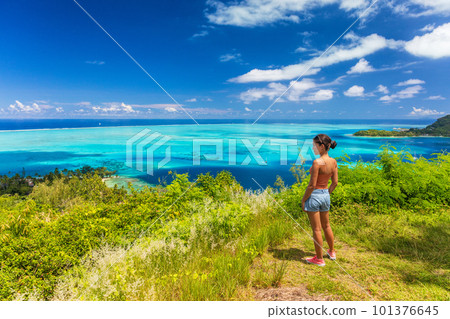 Bora Bora Tahiti cruise travel shore excursion tourist woman hiking on hike trail top view of lagoon and island, French Polynesia. 101376645