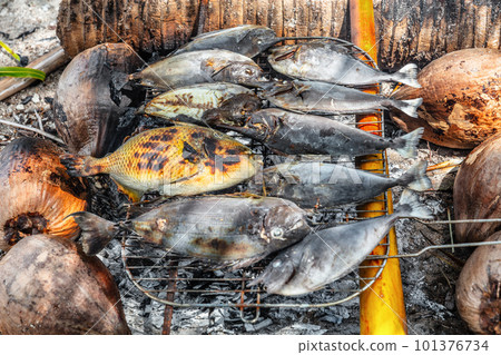 Polynesian fish bbq traditional French Polynesia food on the beach - motu picnic cruise tour luau in Fakarava, Tahiti, French Polynesia. Grilled fish on coconut charcoal and palm tree wood barbecue. Polynesian fish bbq traditional French Polynesia food on the beach - motu picnic cruise tour luau in Fakarava, Tahiti, French Polynesia. Grilled fish on coconut charcoal and palm tree wood barbecue. 101376734