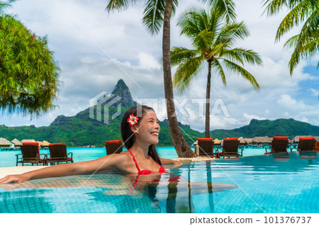 Luxury hotel vacation resort Asian woman tourist relaxing in swimming pool enjoying tropical getaway in Bora Bora, Tahiti, French Polynesia. Luxury hotel vacation resort Asian woman tourist relaxing in swimming pool enjoying tropical getaway in Bora Bora, Tahiti, French Polynesia. 101376737