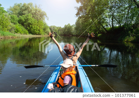 Family kayak trip. Mom and daughter rowing a boat on the river, a water hike, a summer adventure. Eco-friendly and extreme tourism, active and healthy lifestyle Family kayak trip. Mom and daughter rowing a boat on the river, a water hike, a summer adventure. Eco-friendly and extreme tourism, active and healthy lifestyle 101377061