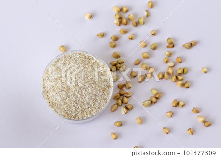 Gluten-free green buckwheat flour on white background. Top view, close-up 101377309