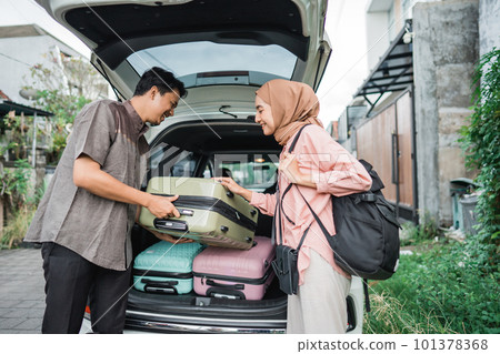 muslim couple packing suitcase in the car muslim couple packing suitcase in the car 101378368