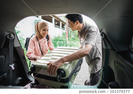 muslim couple packing suitcase in the car 101378377