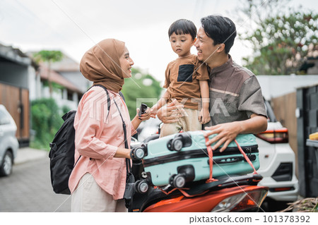 asian muslim family riding motorbike scooter together traveling with kid 101378392