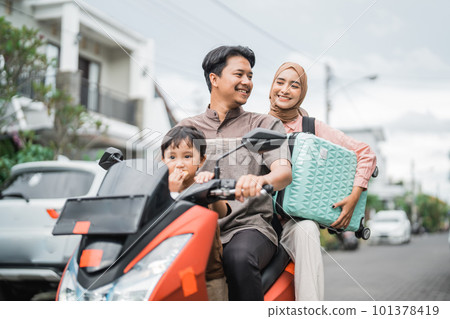 asian muslim family riding motorbike scooter together traveling with kid 101378419