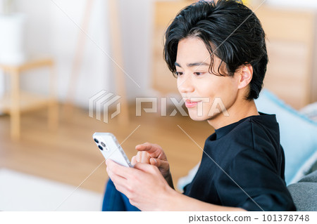 操作智能手機的一個年輕人 101378748