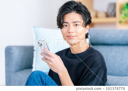 操作智能手機的一個年輕人 101378778