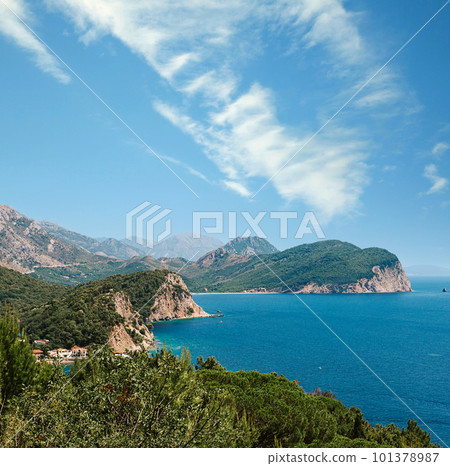 Picturesque view on rocks on a sunny day from the sea. Budva riviera, Montenegro. Aerial view of Sveti Nikola, Budva island, Montenegro. Hawaii beach, umbrellas and bathers and crystal clear waters 101378987