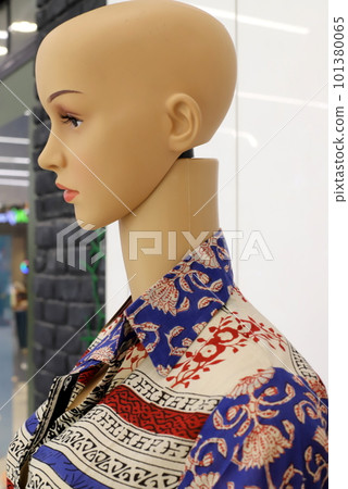 a mannequin stands on a shop window 101380065