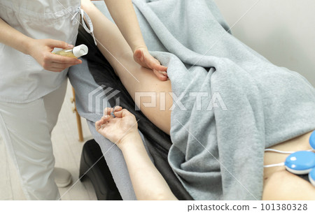 Cropped Doctor Gives Manual Massage To A Patient With Athetosis Disorder. White Woman Is Lying On Couch In Medical Room. Closeup, Horizontal Plane 101380328