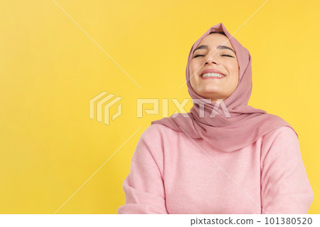 Happy muslim woman laughing with eyes closed Happy muslim woman laughing with eyes closed 101380520