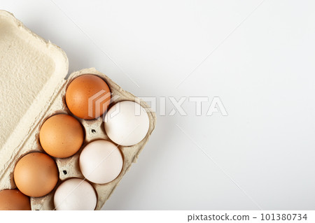 Raw chicken eggs in an egg tray on a white background. 101380734
