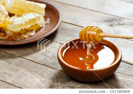 honey in bowl with dipper and honeycomb on wooden table honey in bowl with dipper and honeycomb on wooden table 101380969