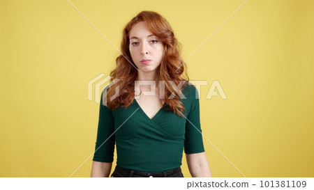Redheaded woman looking at camera with an angry expression 101381109