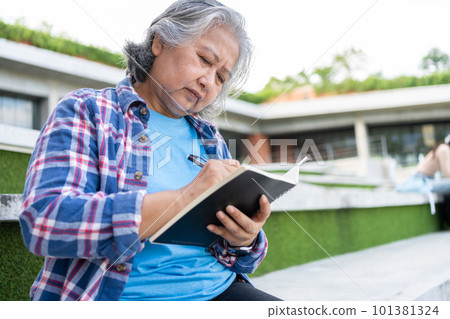 Mature adult student sitting in front off College building and reading school books after attending a university class, Adult education Learning Studying Happy Asian Elderly retired activity Mature adult student sitting in front off College building and reading school books after attending a university class, Adult education Learning Studying Happy Asian Elderly retired activity 101381324