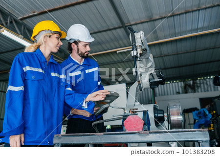 Team engineer using remote robot controller operate standing at automation robot arms machine 101383208