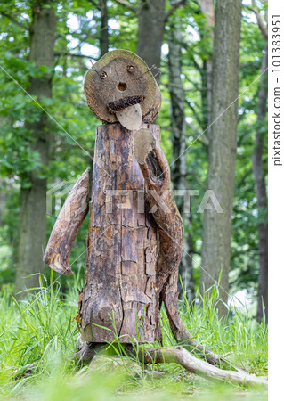 Funny figure made of wood stands in the woods. 101383951
