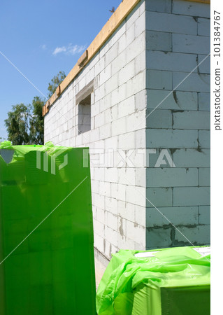 Corner of a house of a white wall from aerated concrete at a construction site.  101384767