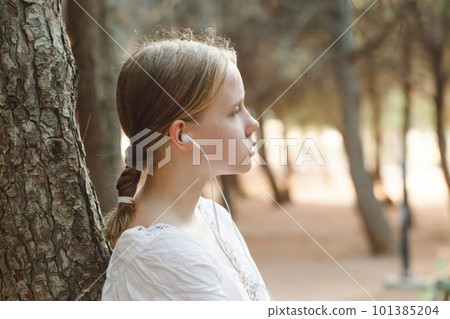 Porrait of pretty teenage girl in white shirt listen to music in headphones  101385204