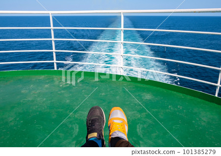 Legs in different sneakers on the background of a water trail on a cruise ship. Legs in different sneakers on the background of a water trail on a cruise ship. 101385279