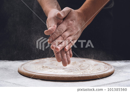 Bakers hands in flour on the table, close-up. Sprinkling some flour on dough. Hands kneading dough 101385560