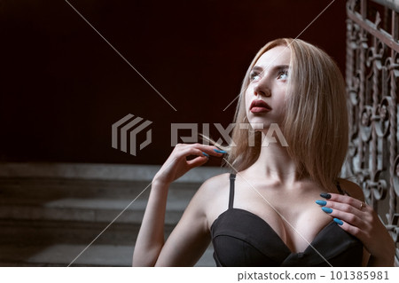 Portrait of fair-haired young woman with sad gaze in top with plunging neckline inside. Sexy blonde model in pushup bra Portrait of fair-haired young woman with sad gaze in top with plunging neckline inside. Sexy blonde model in pushup bra 101385981
