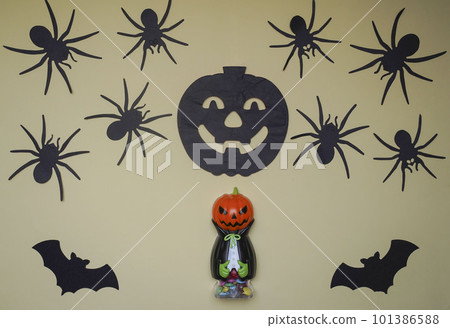 Scary Halloween figurines stand on a light background in close-up, behind hangs terrible pumpkin Scary Halloween figurines stand on a light background in close-up, behind hangs terrible pumpkin 101386588