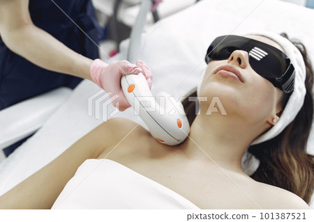 Cosmetologist use laser. Woman with cosmetologist. Lady in a beauty studio. Cosmetologist use laser. Woman with cosmetologist. Lady in a beauty studio. 101387521