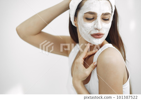 Cosmetology theme. Girl in a white bandage. Woman with mask on face. Cosmetology theme. Girl in a white bandage. Woman with mask on face. 101387522