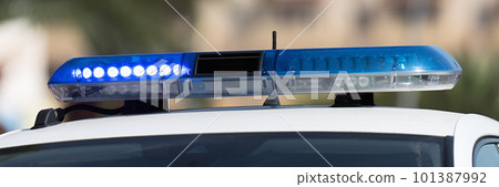 Flasher on blue light of patrol police car on street. Emergency sirens on vehicles for urgent situation, closeup of blue lights on roof of police car Flasher on blue light of patrol police car on street. Emergency sirens on vehicles for urgent situation, closeup of blue lights on roof of police car 101387992