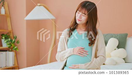 asia woman pregnant stroking belly 101389365