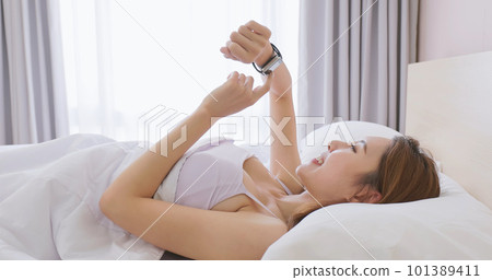 Woman wake up with smartwatch 101389411