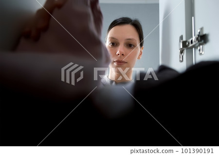 Young woman takes clothes from the closet, closeup view. 101390191