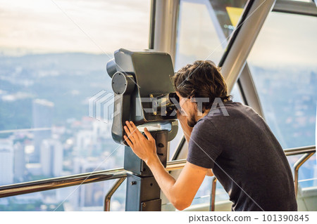 Man looks at Kuala lumpur cityscape. Panoramic view of Kuala Lumpur city skyline evening at sunset skyscrapers building in Malaysia Man looks at Kuala lumpur cityscape. Panoramic view of Kuala Lumpur city skyline evening at sunset skyscrapers building in Malaysia 101390845