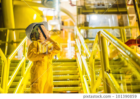 Boy operator recording operation of oil and gas process at oil and rig plant, offshore oil and gas industry, offshore oil and rig in the sea, operator monitor production process, routine daily record 101390859
