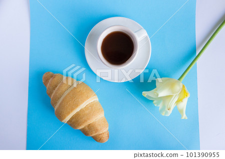 cup of coffee on a blue background, a tulip flower and a french croissant. breakfast concept cup of coffee on a blue background, a tulip flower and a french croissant. breakfast concept 101390955